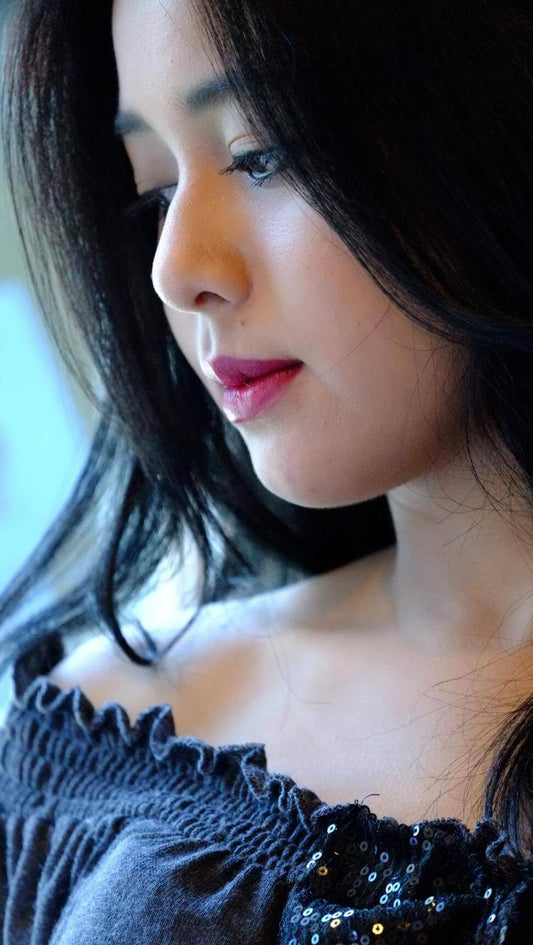 Close-up profile of a woman with smooth skin and dark hair, embodying the glass skin aesthetic.