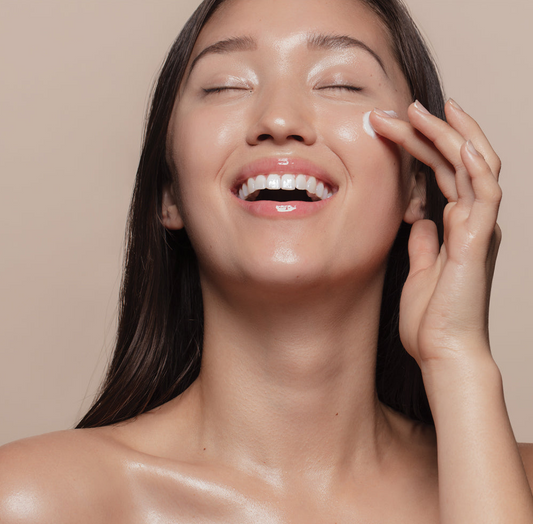 Woman with glowing skin applying skincare product, embodying the essence of K-Beauty and a radiant skincare routine.