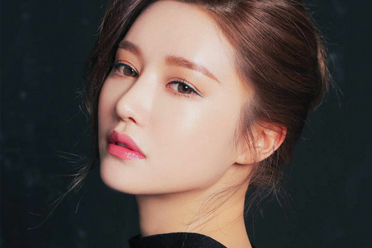 Close-up portrait of a woman showcasing flawless skin and a natural makeup look.