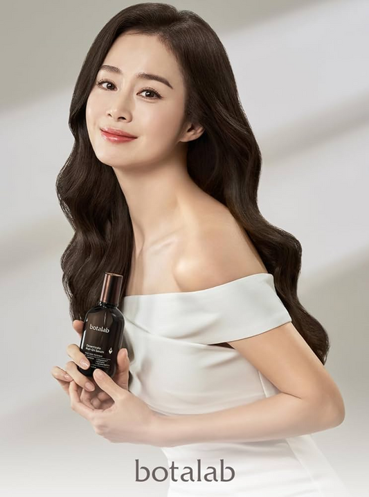 Woman with shiny, wavy hair holding Botalab hair care product, promoting healthy hair.
