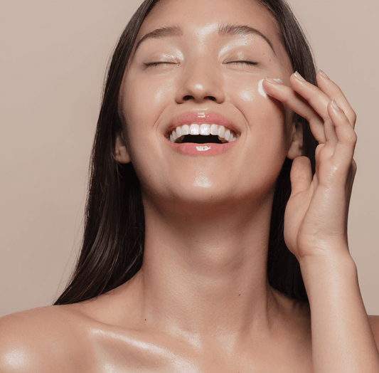 Woman smiling while applying Riman Incellderm Active Cream EX for radiant skin.