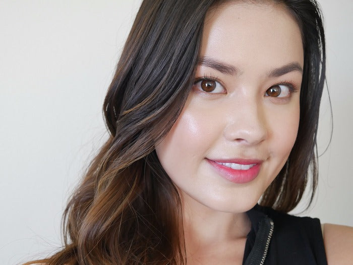 Smiling young woman with radiant skin showcasing results from Riman Incellderm Collagen 100 Melting Sheet Mask.
