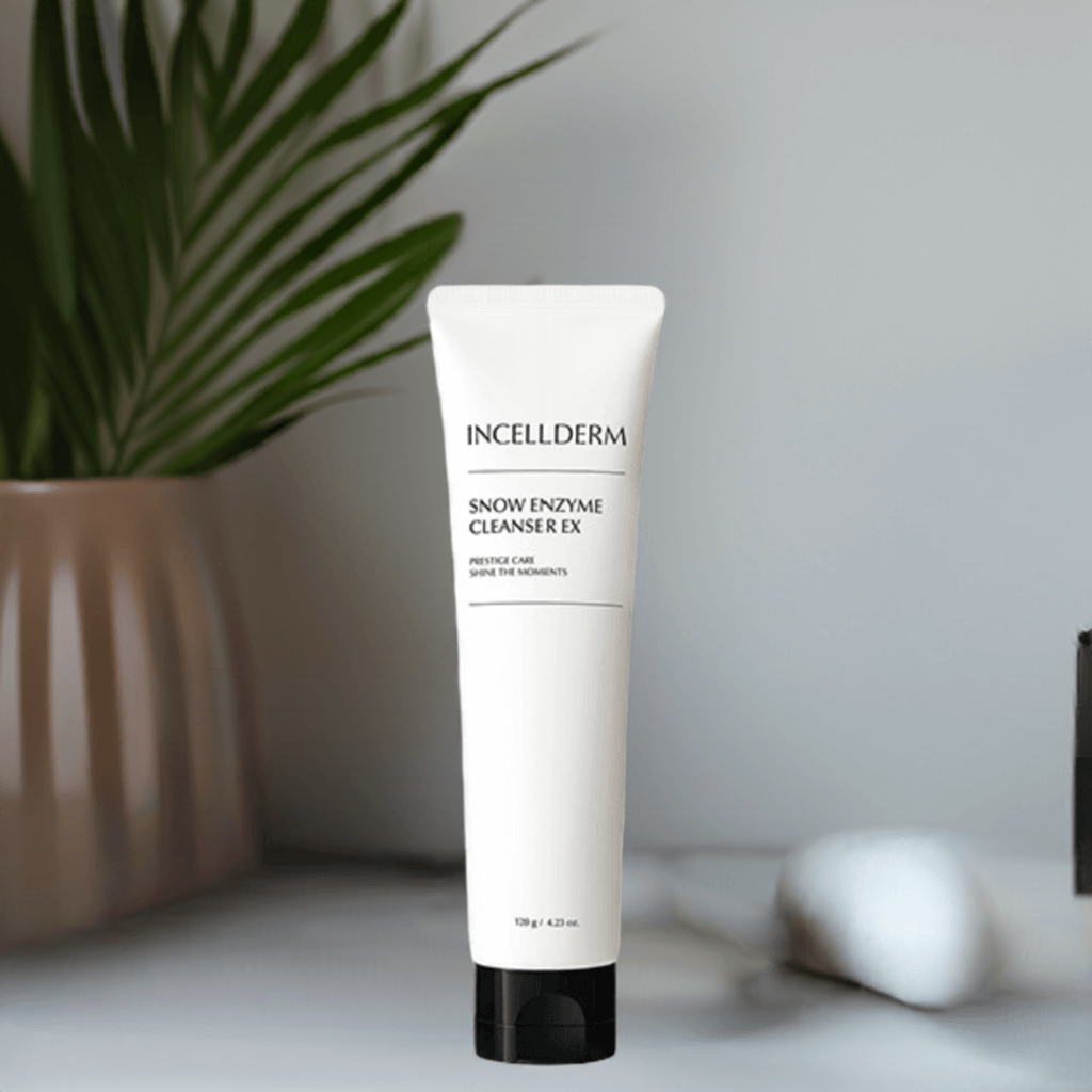 Incellderm Snow Enzyme Cleanser EX tube on a stylish bathroom counter surrounded by greenery.
