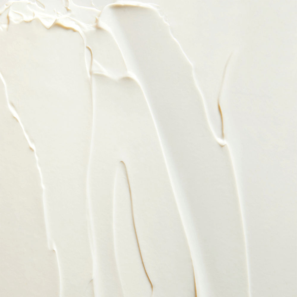 Textured close-up of white moisturizer, showcasing smooth application for skin hydration.
