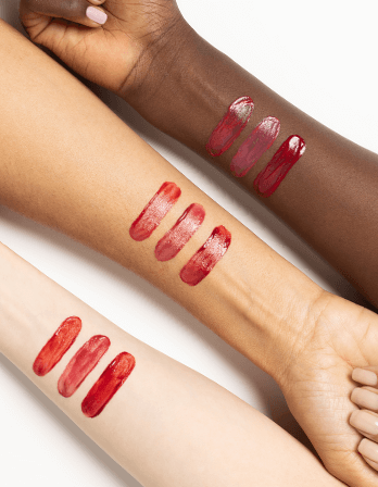 Swatches of ICD Makeup Butter Lip Tint Semi Matte on diverse skin tones, showcasing vibrant red hues.