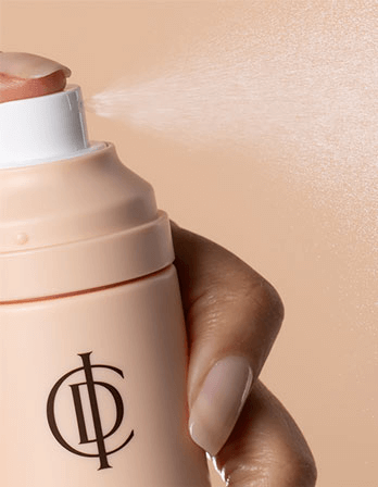 Close-up of hand activating ICD Makeup Set & Stay Makeup Spray, misting skin for a flawless finish.