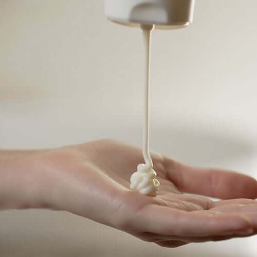 Hand receiving Suamel Nourishing Body Cream, showcasing its rich and creamy texture for hydration.