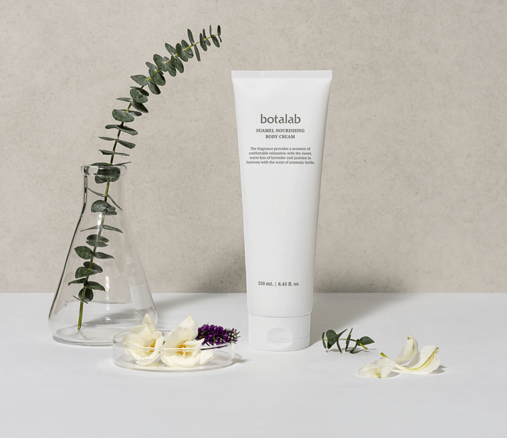 Suumel Nourishing Body Cream tube next to flowers and greenery, showcasing hydration and soothing benefits.