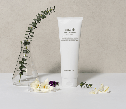 Suumel Nourishing Body Cream tube next to flowers and greenery, showcasing hydration and soothing benefits.