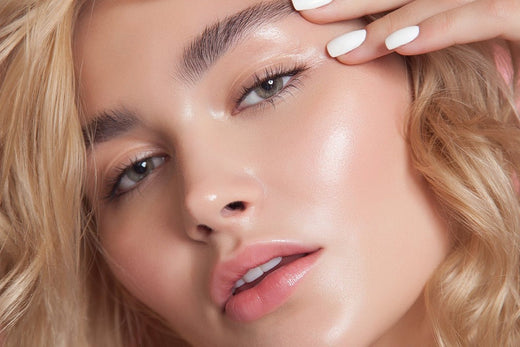 Close-up of a woman with radiant skin and soft waves, showcasing a natural, glowing look indicative of effective skincare.