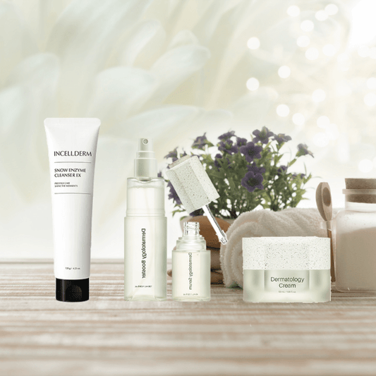 Close-up of Riman ICD Mini Ritual Set - Snow Enzyme Cleanser, Dermatology First Package booster and serum bottles and Dermatology Cream with natural lighting and green accents